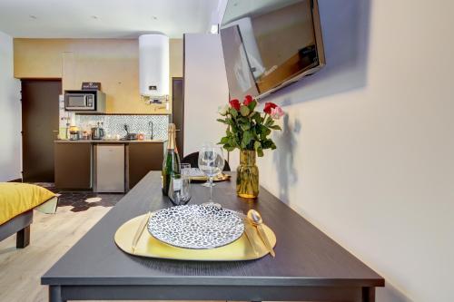 une table à manger avec une plaque jaune et un vase de fleurs dans l'établissement Love Avenue 51 - Studio proche du centre, à Reims