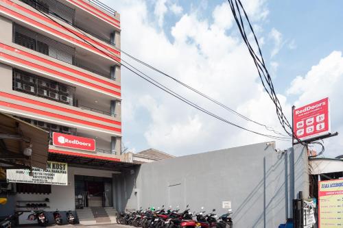 a group of motorcycles parked outside of a building at RedDoorz near Binus Anggrek 2 in Jakarta