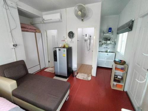eine kleine Küche mit einem Sofa und einem Kühlschrank in der Unterkunft Min Home in Lamphun