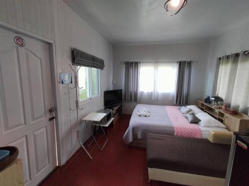 sypialnia z łóżkiem, krzesłem i drzwiami w obiekcie Min Home w mieście Lamphun