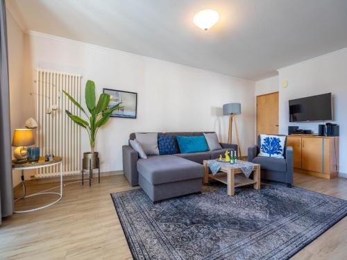 ein Wohnzimmer mit einem Sofa und einem Tisch in der Unterkunft Strandvillen Binz - Ferienwohnung mit 1 Schlafzimmer und Balkon AH-723 in Binz