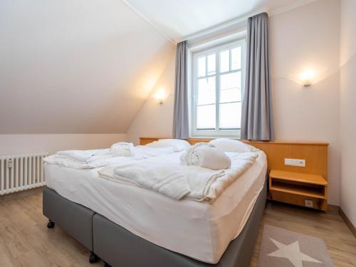 ein großes Bett in einem Zimmer mit einem großen Fenster in der Unterkunft Strandvillen Binz - Ferienwohnung mit 1 Schlafzimmer und Balkon AH-723 in Binz