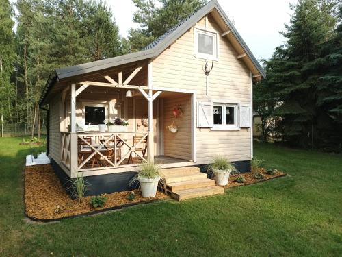 a small shed with a porch and stairs in a yard at Chatka Jezioranka & bania in Kolonia Siedlątków