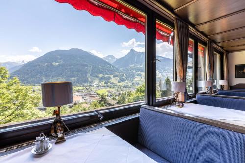 a room with a table with a view of mountains at keyone rooms Montafon in Schruns