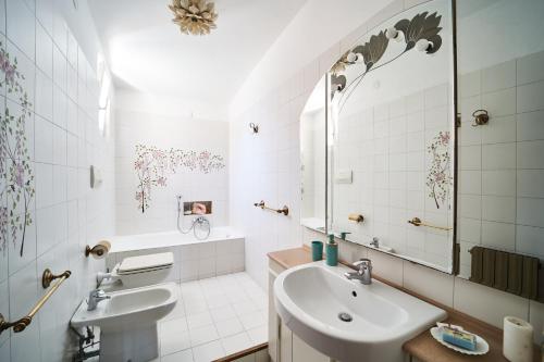 ein weißes Badezimmer mit einem Waschbecken und einem Spiegel in der Unterkunft Casa Gioconda in Porto Venere