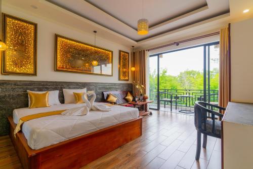 um quarto com uma cama e uma varanda em Angkor Rithy Residence 2 em Phumĭ Réach Born (1)