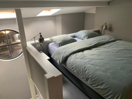 a bedroom with two beds and a mirror at OP ZESTIEN in Hippolytushoef