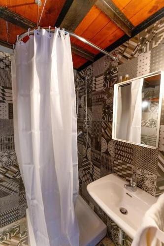 a bathroom with a shower curtain and a sink at Aquatica Home in Polignano a Mare