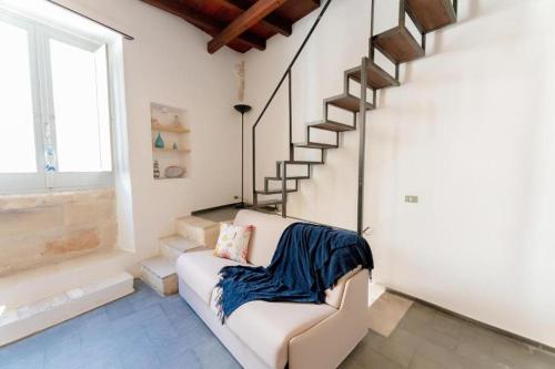 a living room with a white couch and stairs at Aquatica Home in Polignano a Mare