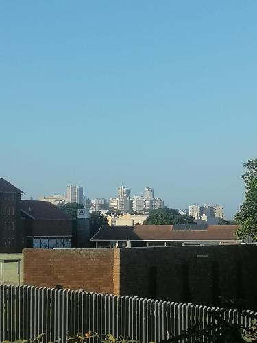 une vue sur une ville avec une clôture et des bâtiments dans l'établissement Glenwood, à Durban