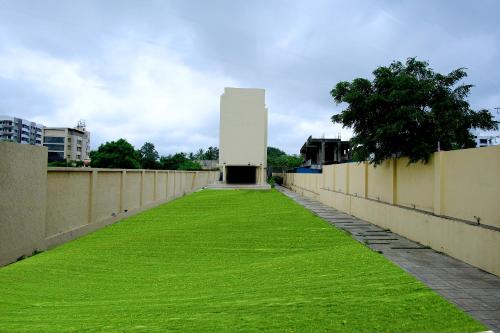 a wall with a field of grass next to a building at Hotel Maharaja in Nashik