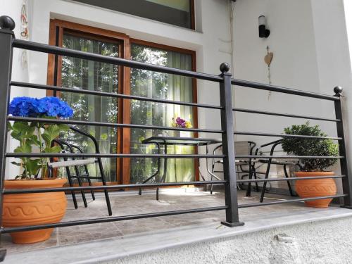 Isidora Apartments في زاغورا: شرفة مع الكراسي والطاولات والنباتات الفخارية