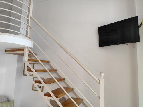 a staircase with a flat screen tv on a wall at Isidora Apartments in Zagora