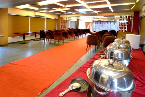 a room with a row of chairs and a table at Hotel Maharaja in Nashik