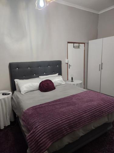 - une chambre avec un grand lit et une couverture rouge dans l'établissement Guest Room, à Boksburg