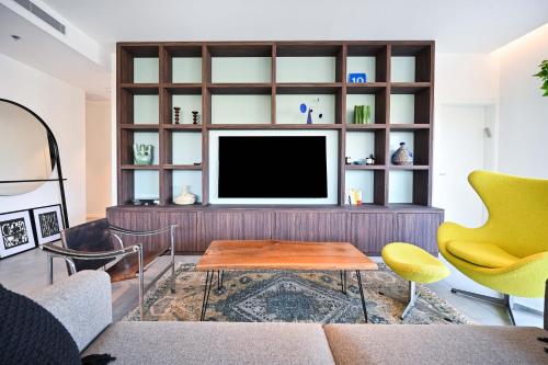 a living room with a tv on a wall at Modern 3BR retreat in the Old North by HolyGuest in Tel Aviv
