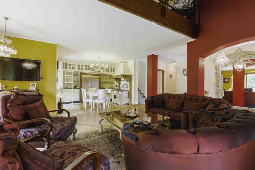 una gran sala de estar con sofás y una mesa. en Villa Marzia en Lanzo dʼIntelvi