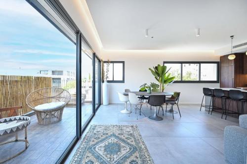an open living room with a table and chairs at Modern 3BR retreat in the Old North by HolyGuest in Tel Aviv