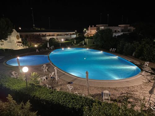 a large blue swimming pool at night at Pausa Mare Seaside in Torre a Mare