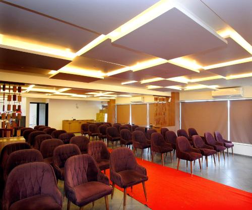 a room with a bunch of chairs and a screen at Hotel Maharaja in Nashik