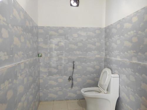 bagno con servizi igienici e nuvole sul muro di Falcon Jungle Resort a Jyoti Gaon