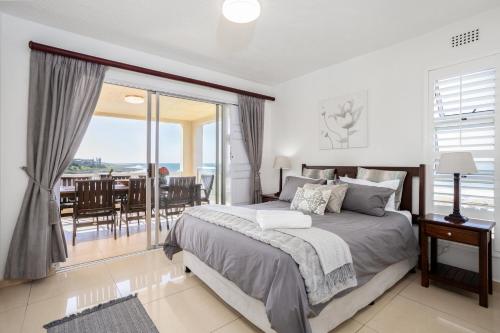 a bedroom with a bed and a view of the ocean at Laguna La Crete 26 in Uvongo Beach