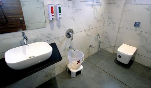 a bathroom with a sink and a toilet at Hotel Maharaja in Nashik