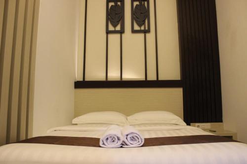 a bed with two towels sitting on top of it at Dawala Hotel in Sudiang