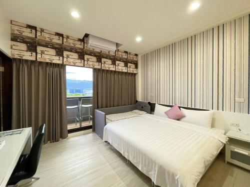 a bedroom with a bed and a large window at WanTon B&B in Dongshan