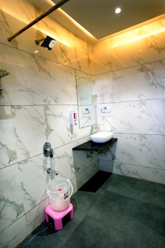 a bathroom with a pink toilet and a sink at Hotel Maharaja in Nashik