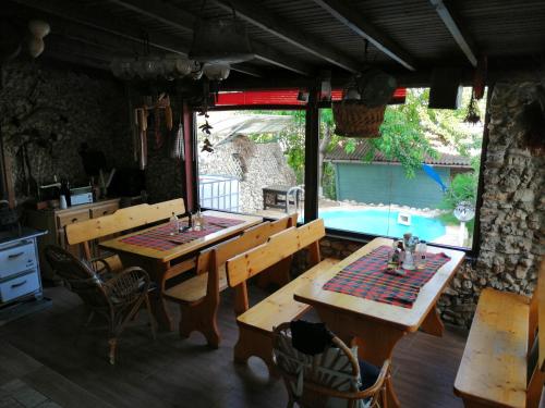 un restaurante con 2 mesas de madera y una piscina en Vila Chasovnikarov, en Golden Sands