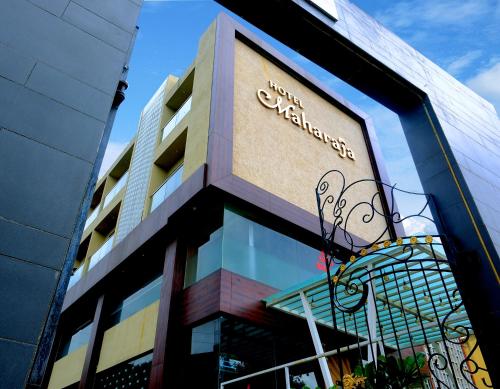 a building with a sign on the side of it at Hotel Maharaja in Nashik
