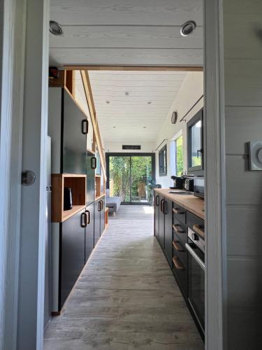 une cuisine avec des armoires noires et un couloir dans l'établissement La Tiny d'Othe, à Estissac