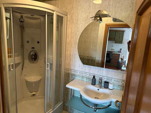 uma casa de banho com um chuveiro, um lavatório e um espelho. em App Trinodis em Basanija