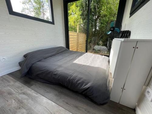 un lit dans une chambre avec une grande fenêtre dans l'établissement La Tiny d'Othe, à Estissac