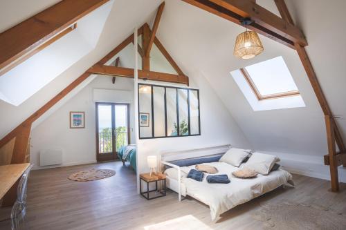 um quarto com uma cama num sótão em La Villa Maxine, vue mer et spa em Criel-sur-Mer