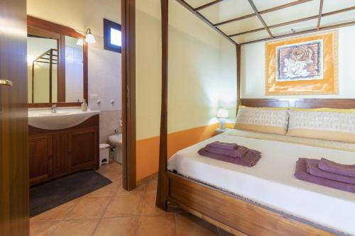 a bedroom with a bed and a bathroom with a sink at Studio Lo Scrigno in Porto Torres
