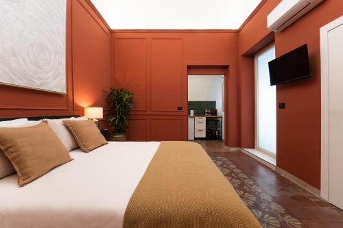 a bedroom with a large bed with orange walls at Kondo Maisons in Catania