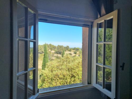 an open window with a view of a field at Les Garrigues de la Vallée des Baux in Paradou