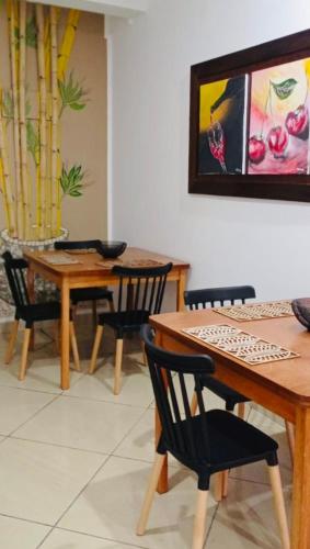 a dining room with two tables and chairs and a painting at Piccolo Bed & Breakfast in Tarapoto