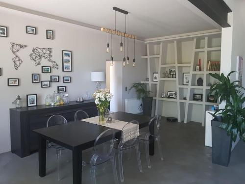 uma sala de jantar com uma mesa preta e cadeiras em Villa familiale au coeur d'un village provençal em Sarrians
