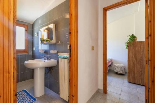 een badkamer met een wastafel en een spiegel bij Casa Pisaro Lu Bagnu in Castelsardo