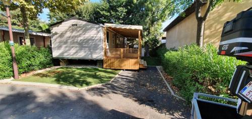 une petite maison avec un porche dans une cour dans l'établissement Mobil-Home VA 04 à Vias - La Carabasse - Camping Siblu avec piscine, à Vias