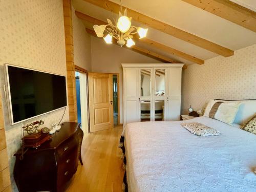 a bedroom with a large bed and a flat screen tv at Doodle's Amazing Chalet -Walensee - Flumserberg - Churfirsten - Heidiland - Pool - Sauna in Mols