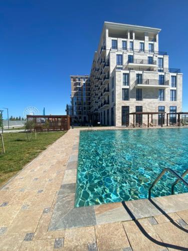 a swimming pool in front of a building at Aktau Riviera in Aktau