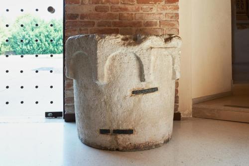 a stone container sitting on the floor next to a brick wall at Villa Martin Hotel in Dolo