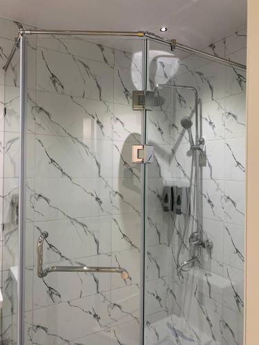 a shower with a glass door in a bathroom at Nur Makon Hotel in Tashkent