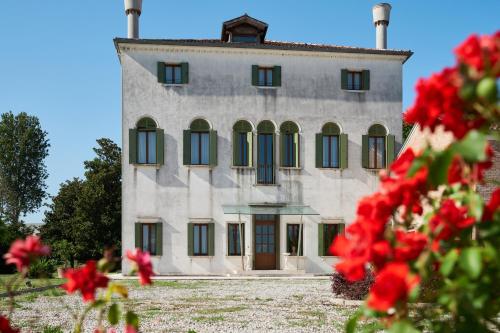 a large building with red flowers in front of it at Villa Martin Hotel in Dolo