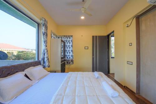 a large bed in a room with a large window at Garava Villa Lonavala in Khandala