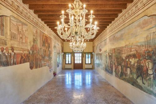a large room with paintings on the walls and a chandelier at Villa Martin Hotel in Dolo